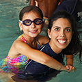 Swim instructor teaching child swim lessons