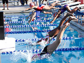 Students diving into the water after their swim lessons
