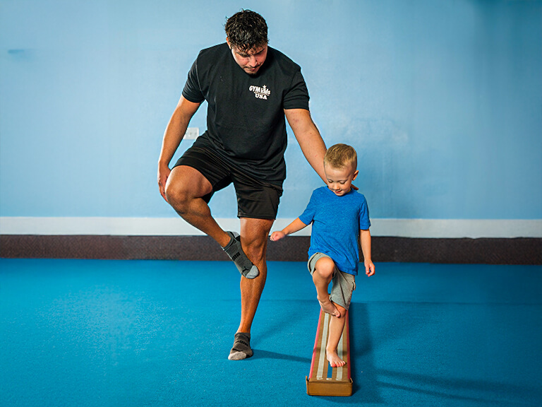 Young student building confidence and balance on the balance beam at GYMKIDS USA in Mesa AZ